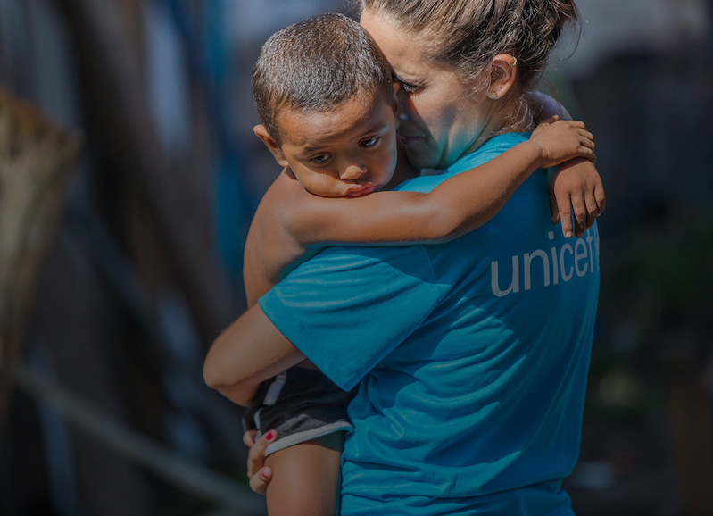 Volontaria UNICEF con un bambino in braccio